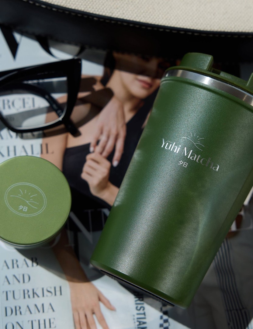 Kit de voyage Yūhi Matcha (mug to go + mini canette de matcha) posé sur un magazine