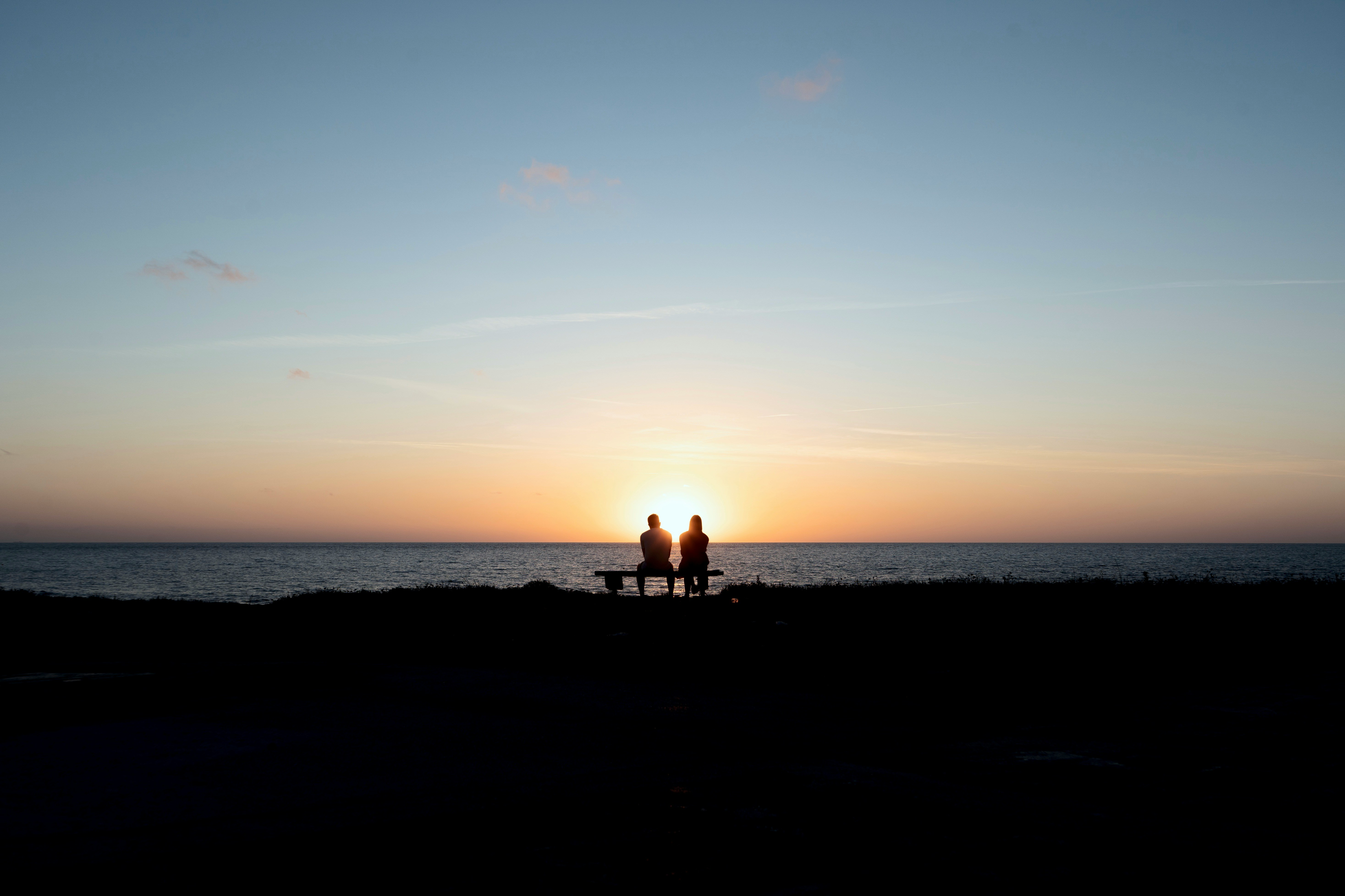 Couple sitting together by the beach.