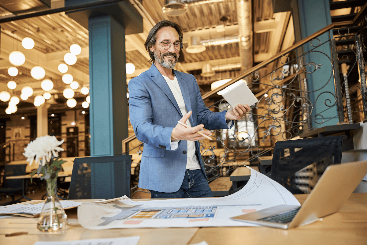 sales methodology: Smiling man doing hand gestures while looking at his laptop