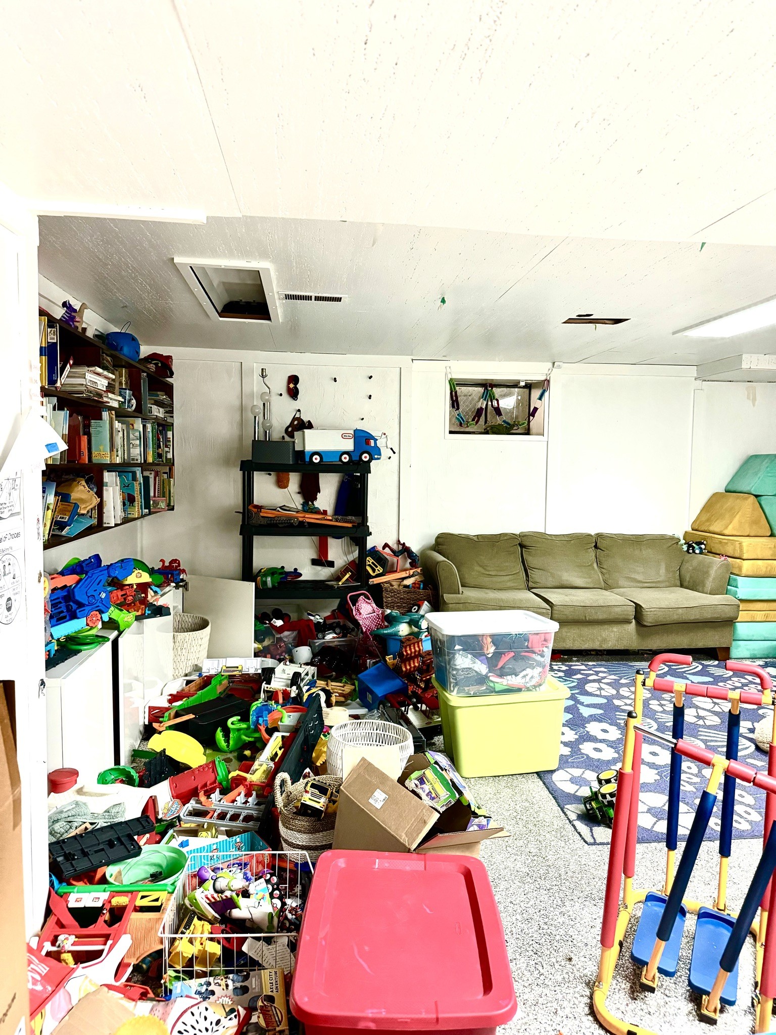 messy basement playroom colorful with rug and toys