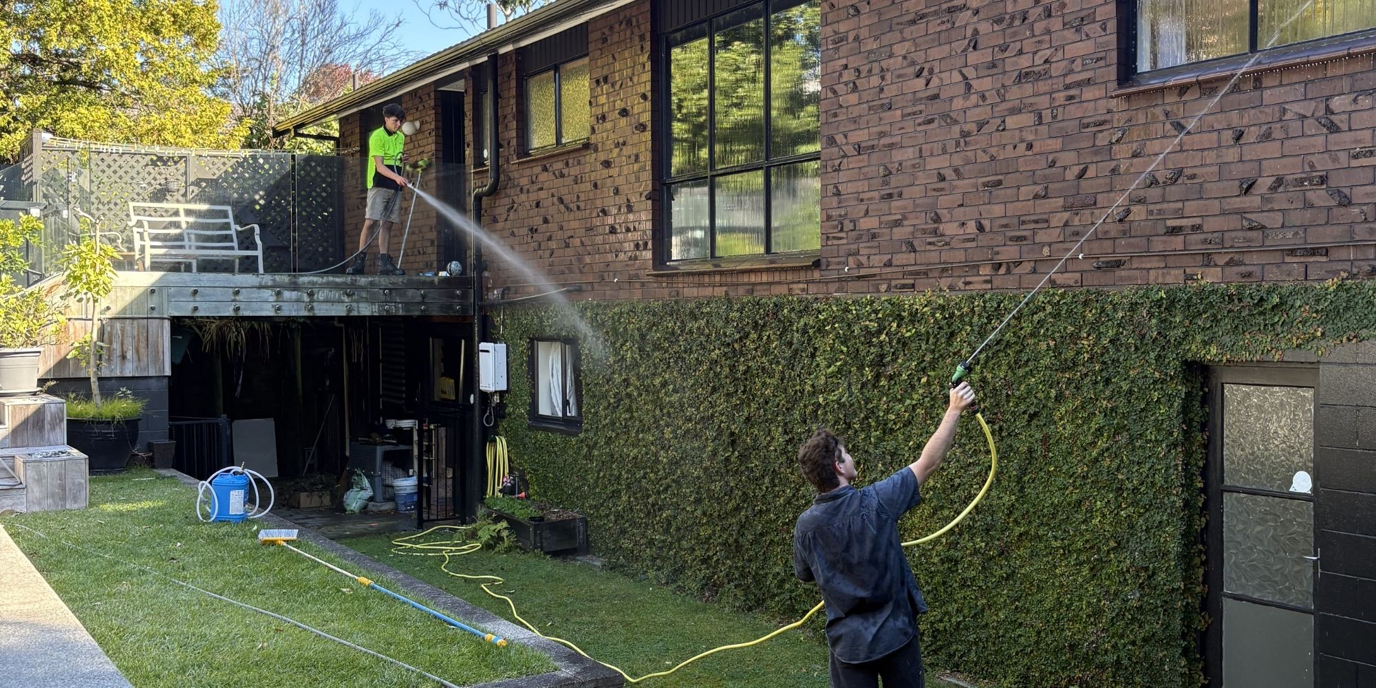 Max soft washing the exterior walls of a Hamilton home using low-pressure cleaning equipment