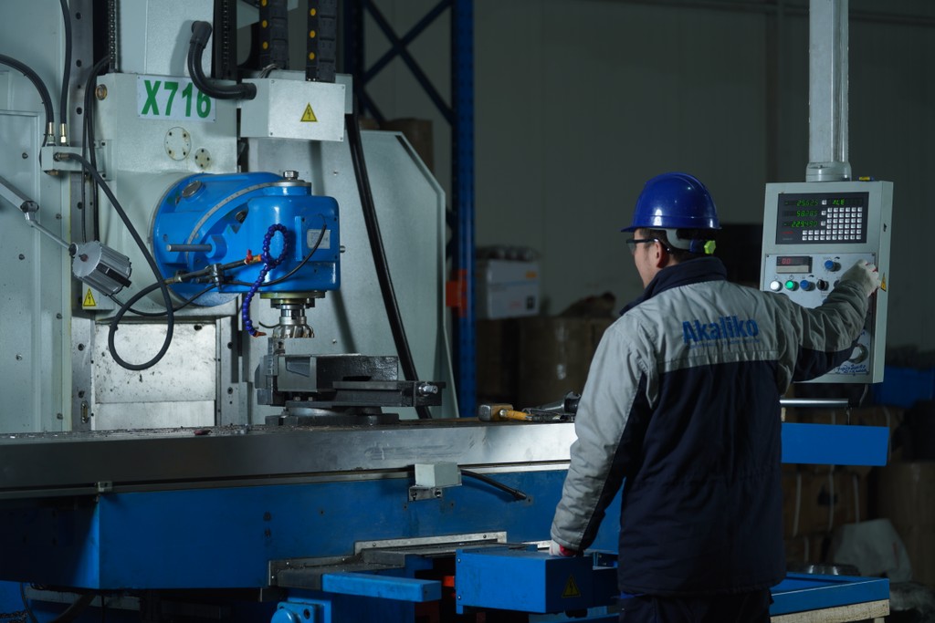 Worker operates CNC machine for aftermarket hydraulic cylinder.