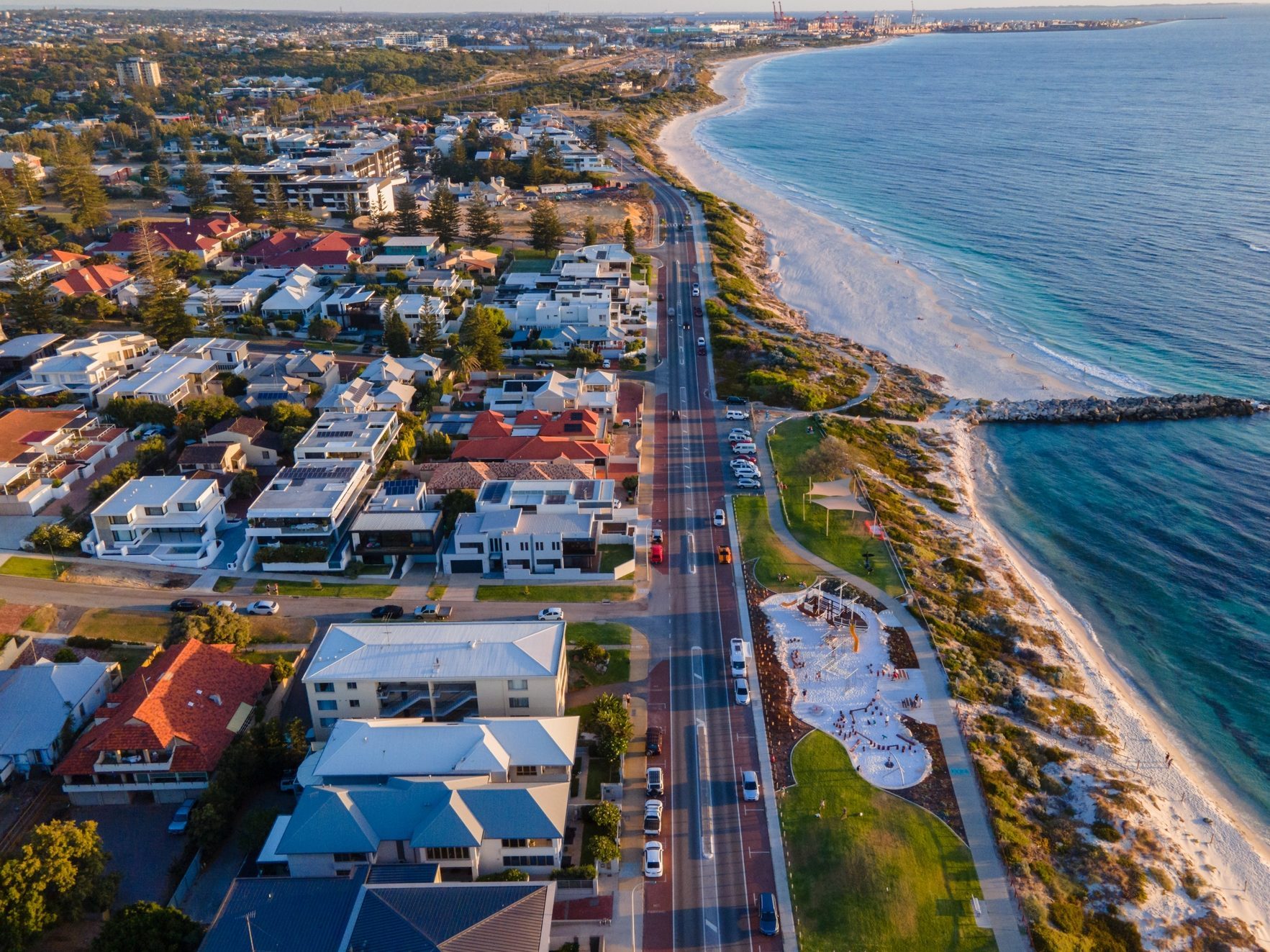 Coastal road with houses, beach, and playground