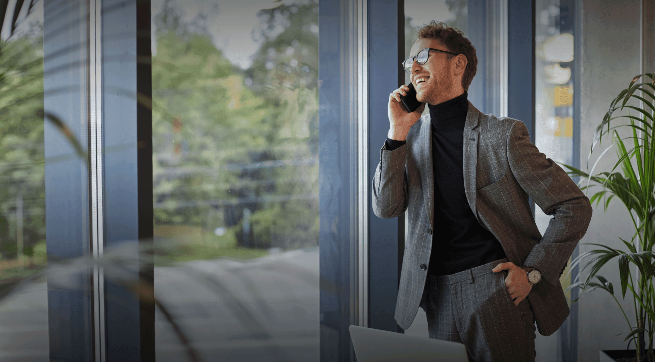 Young businessman in a grey suit on the phone