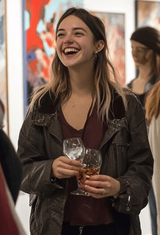 a woman sitting on a window sill looking at her cell phone