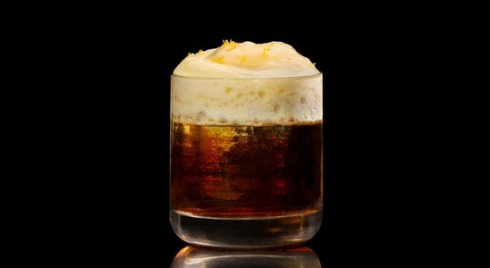 A closeup of a The Barr Americano drink against a dark background.