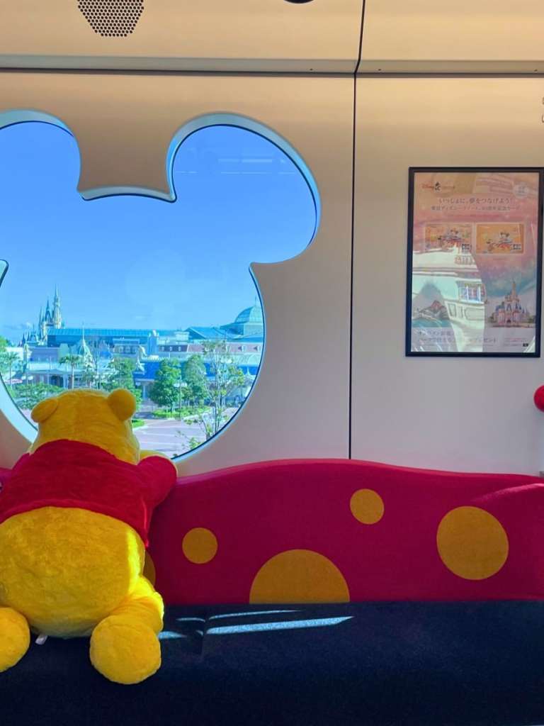 Winnie the Pooh looking out the window on a Disney monorail