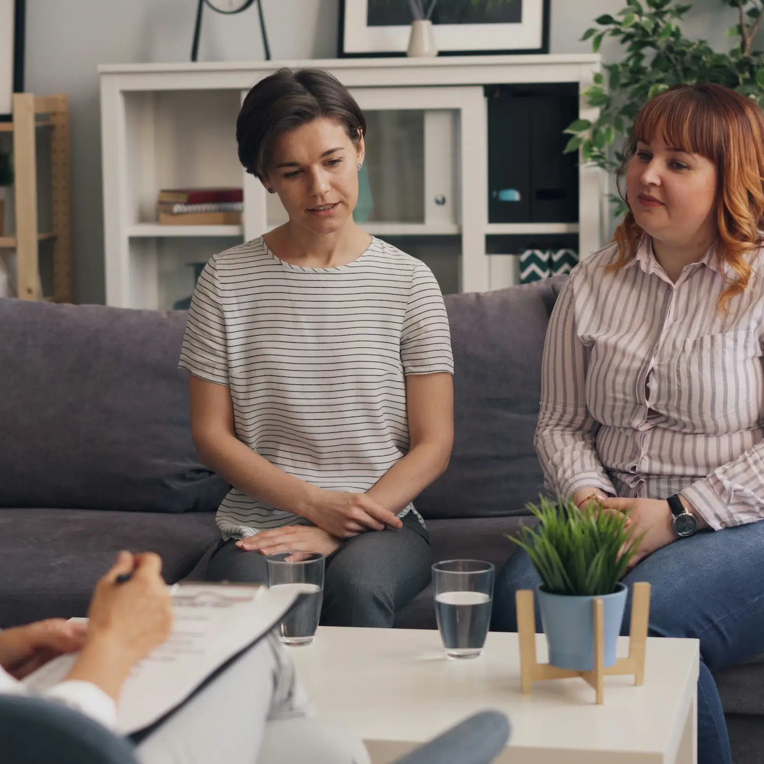 Two people sitting on a couch during a supportive group therapy session in Los Angeles, discussing healing, connection, and growth.