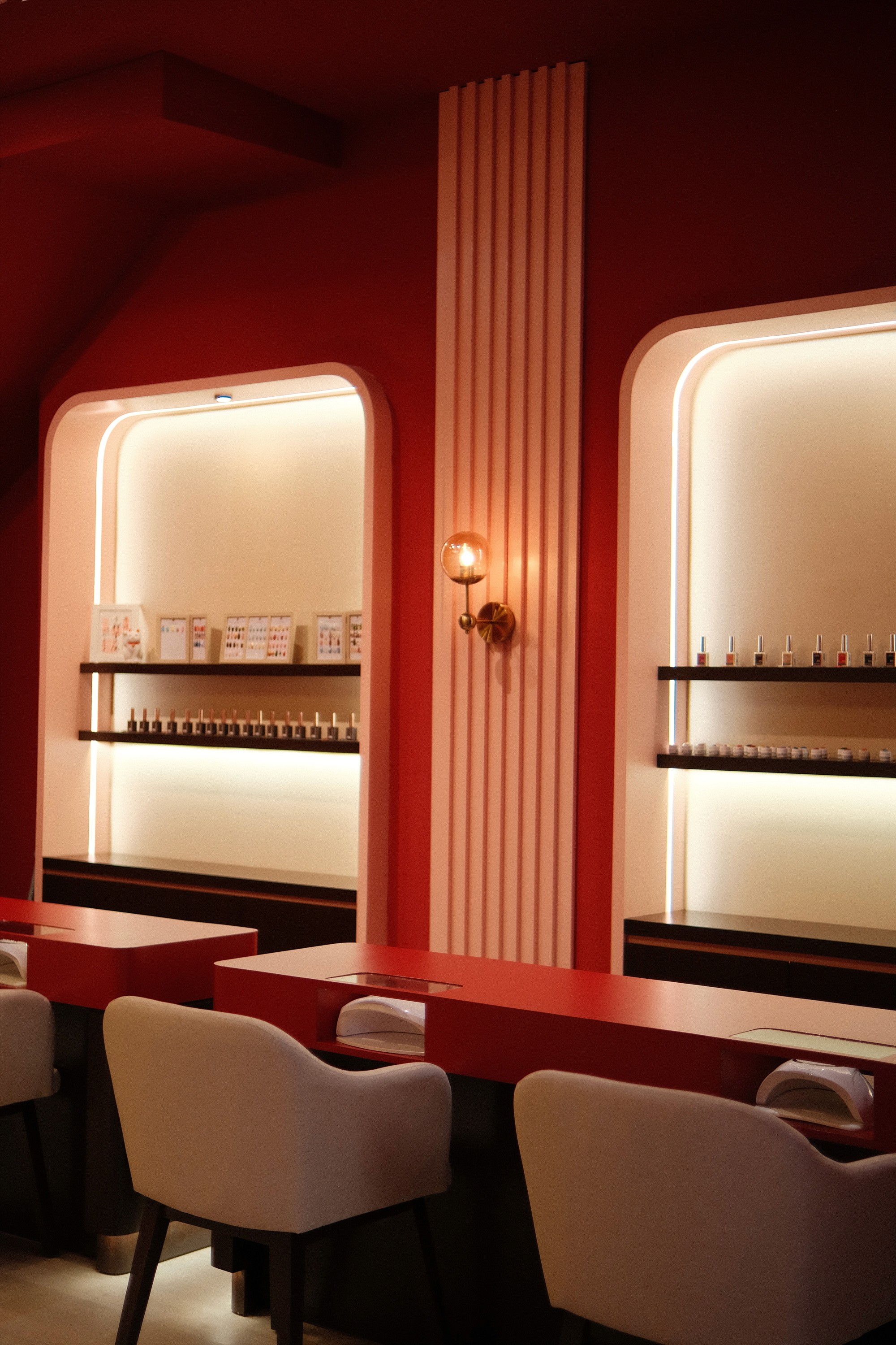 Woman in kimono with bold red lipstick and nails, poses with hands near her face with a smile.