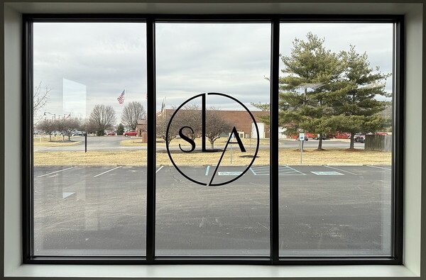 A close-up of a hand gently inserting a small device into someone's ear.