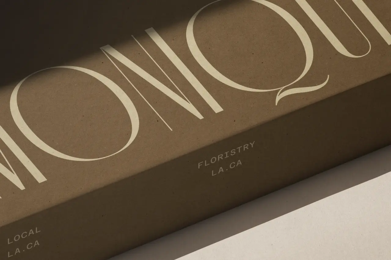 Close-up of a brown floral packaging box with large cream typography.