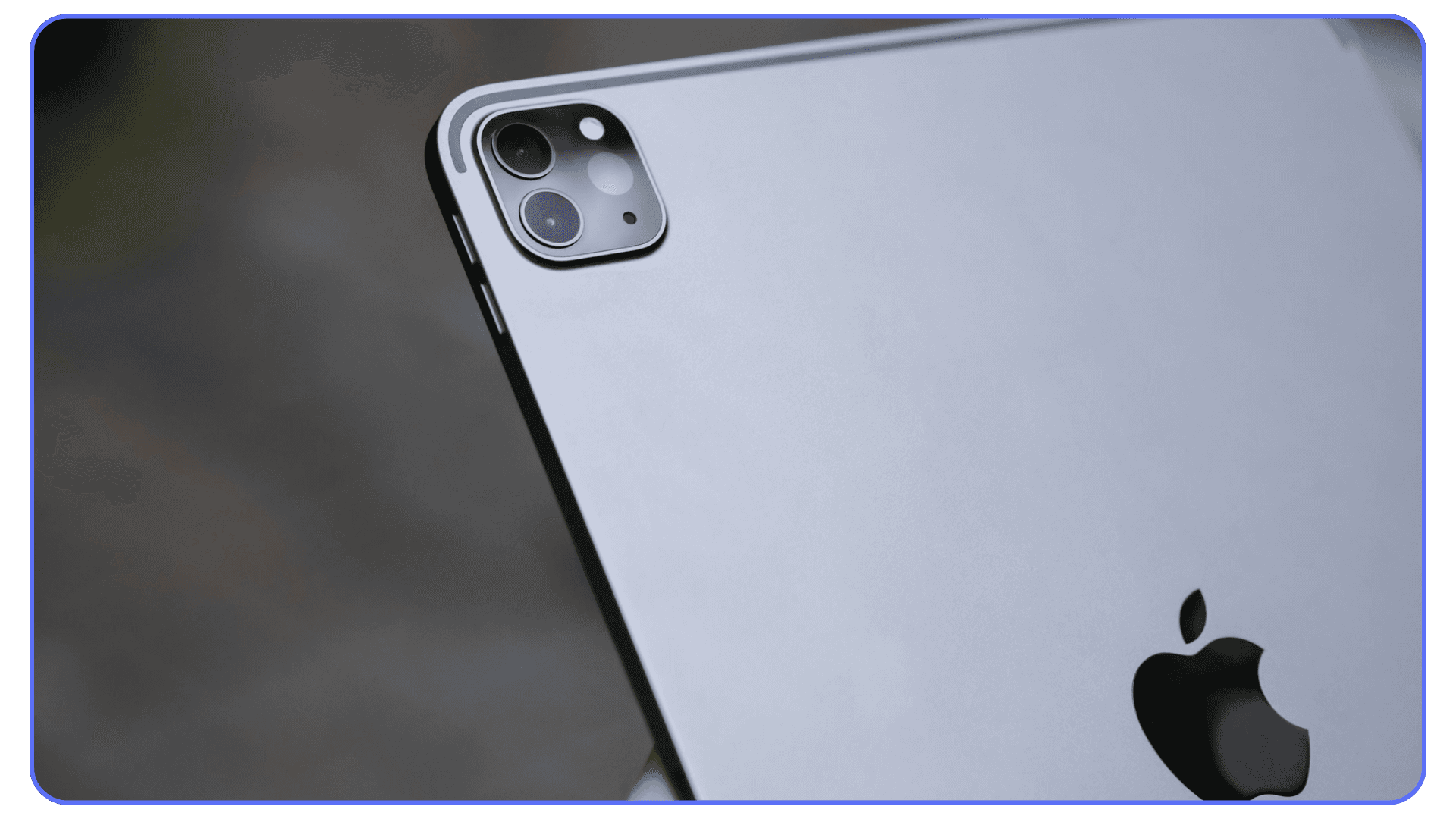 Back view of an Apple iPad showing the rear camera module and Apple logo in focus.