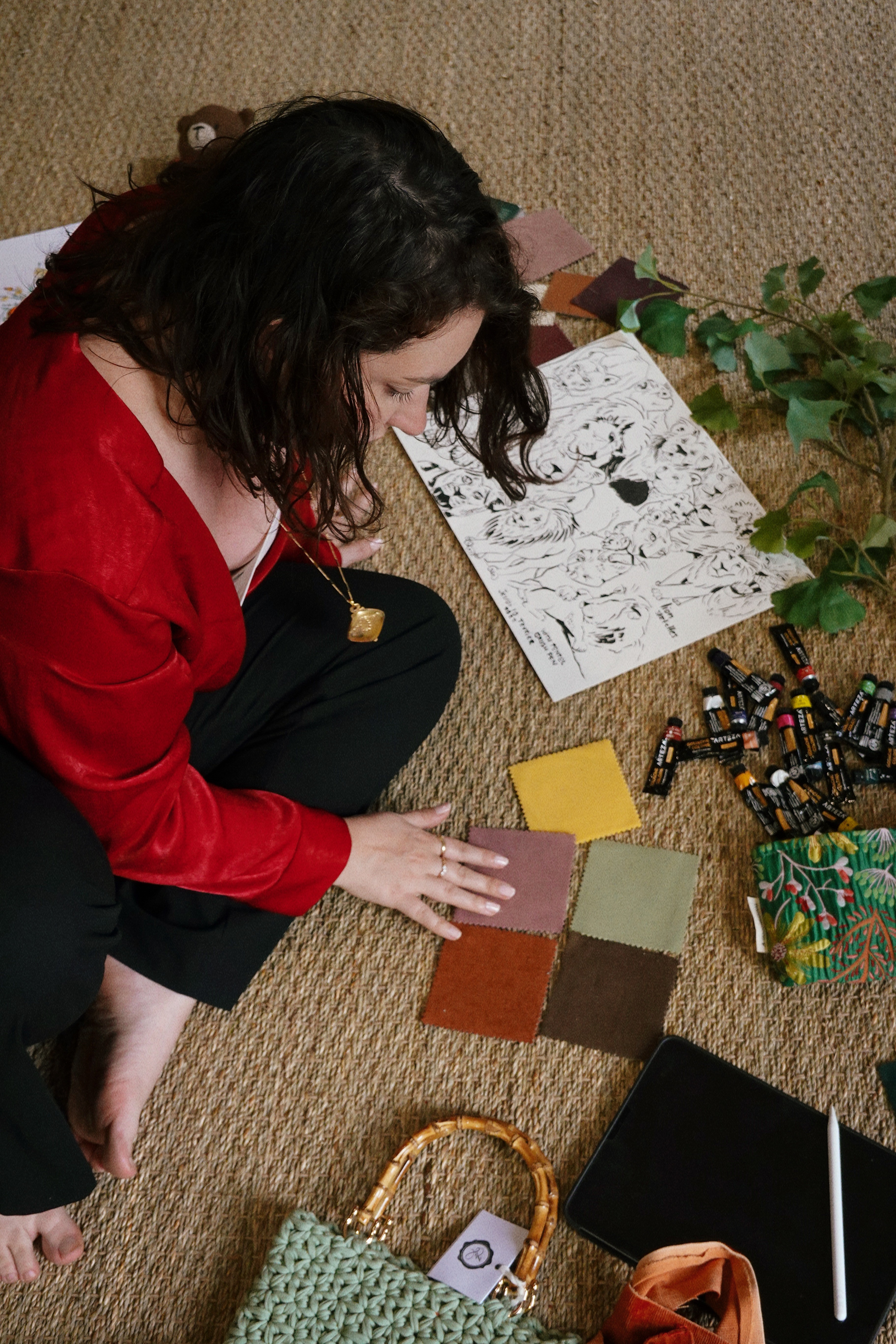 Woman in red outfit poses by a red telephone booth.