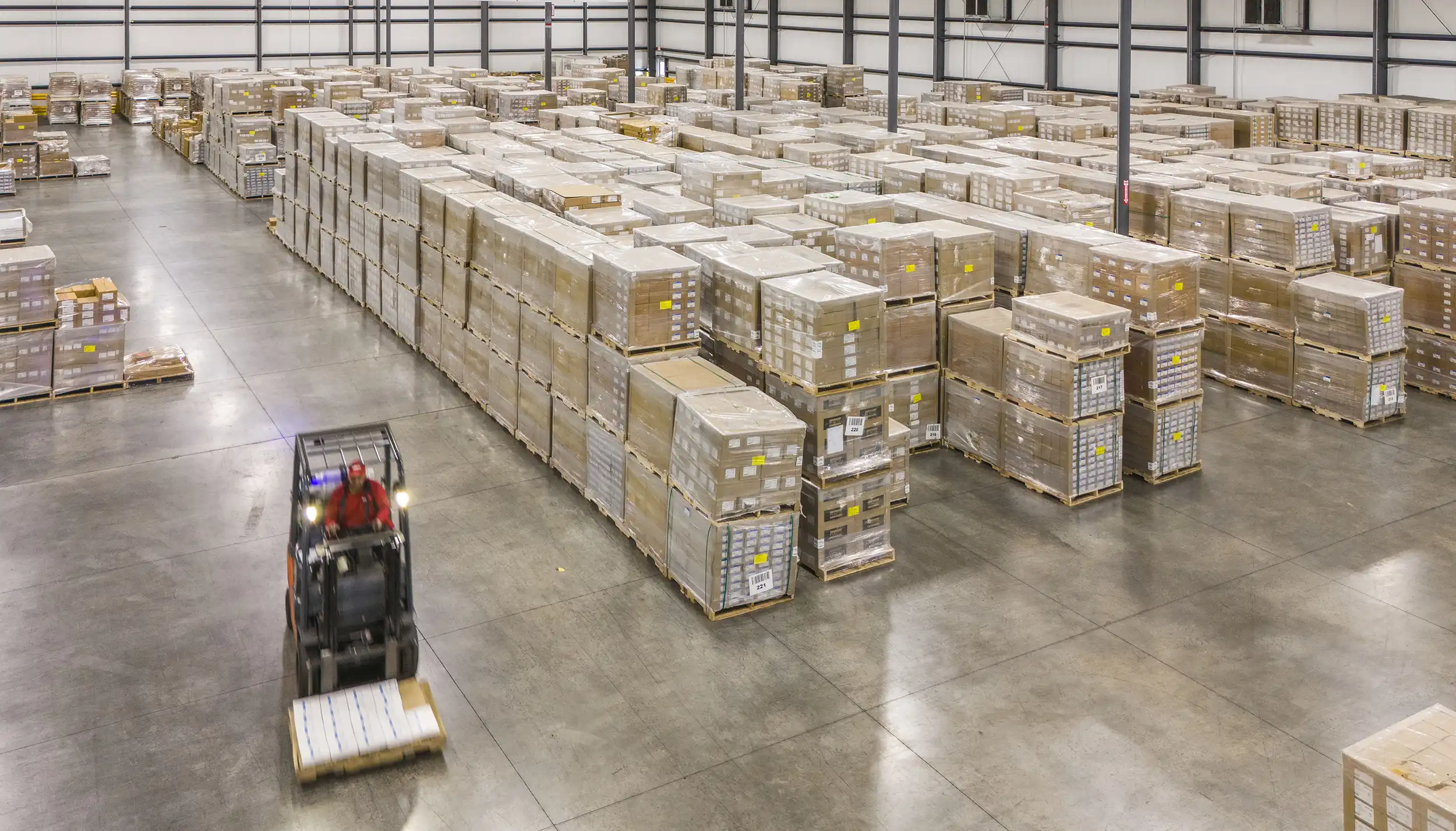 The image captures a moment of dynamic motion, depicting a male basketball player in mid-air as he reaches to shoot or pass the basketball.