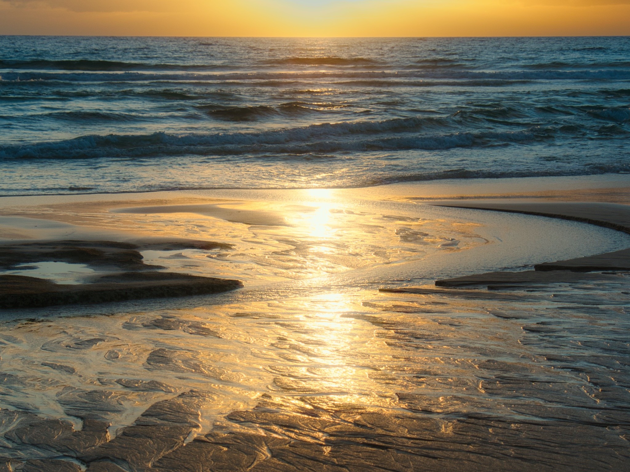 Sonnenaufgang am Meer mit Salzspiegelungen