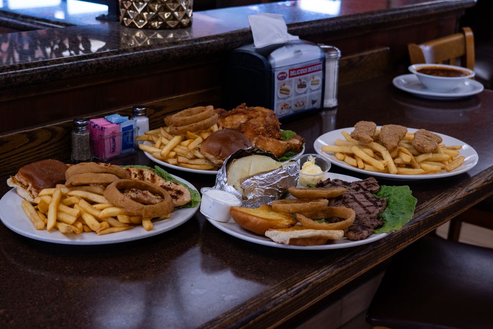 Brunch and lunch plates stacked beside each other served at restaurant Harry's Cafe in Stanton, CA located on Katella Ave.