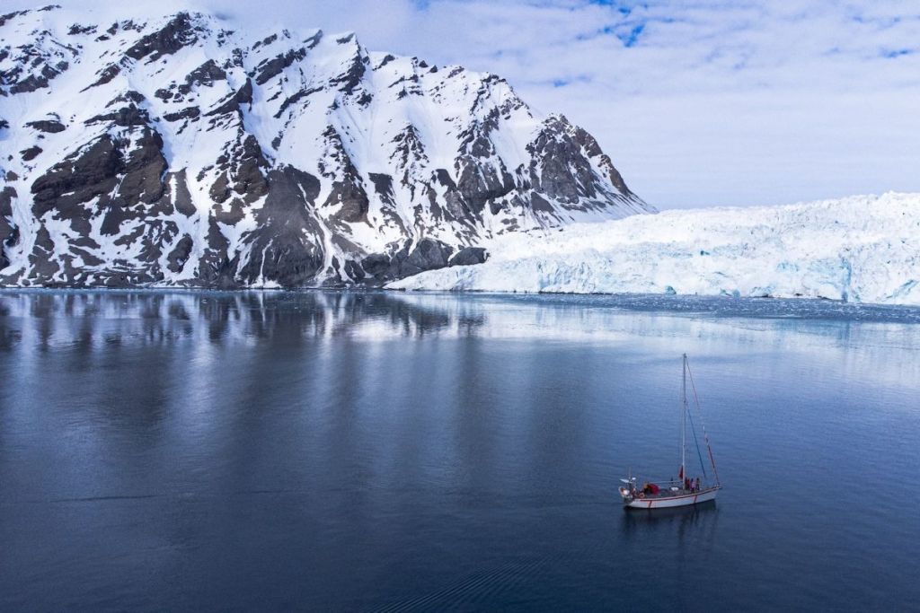 Sail boat in front of the arctic landscape of Svalbard