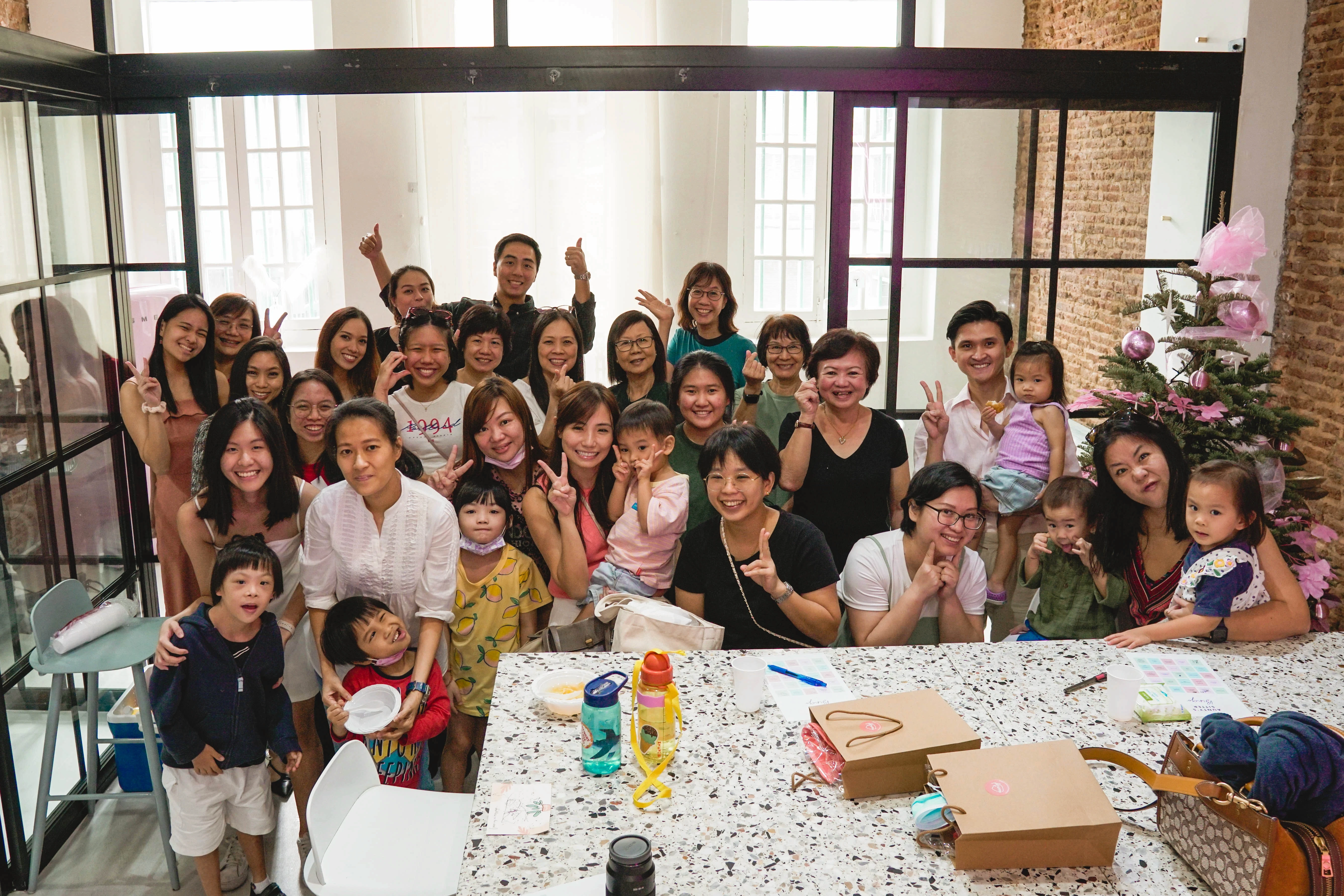 Group of smiling parents, children, and caregivers gathered at an Aunty community event, celebrating family support and childcare services in Singapore.