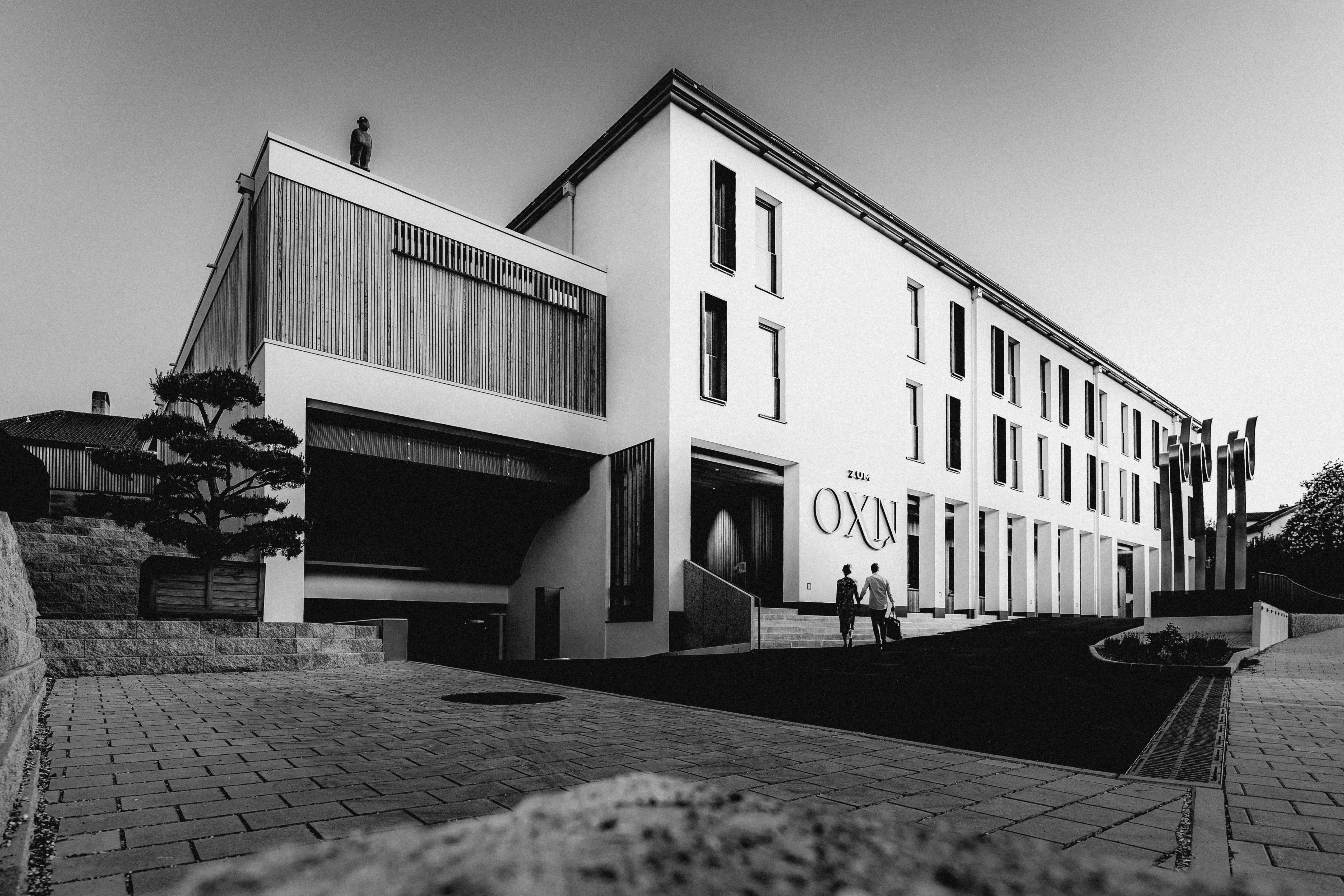 A modern, minimalist building in black and white, featuring large windows and a sleek design.