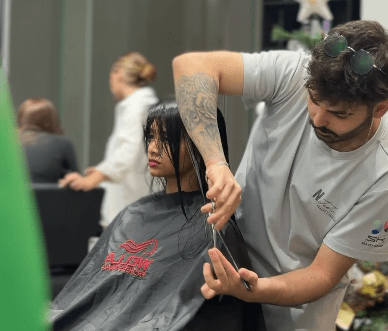 a woman cutting another woman's hair with scissors