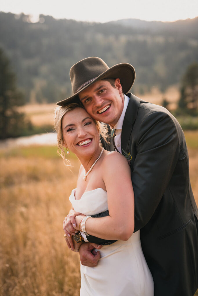 Newlyweds embracing in a sunlit meadow
