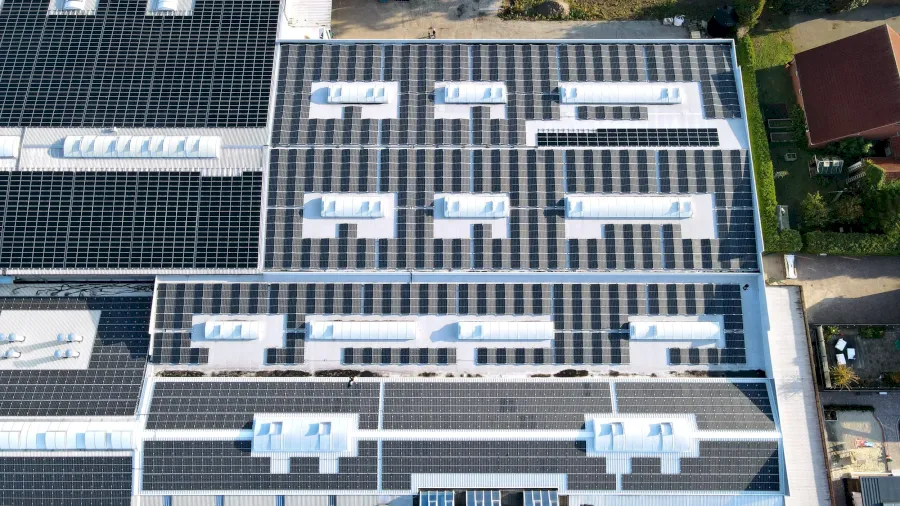 Große Dachfläche mit vielen Solarmodulen und Oberlichtern