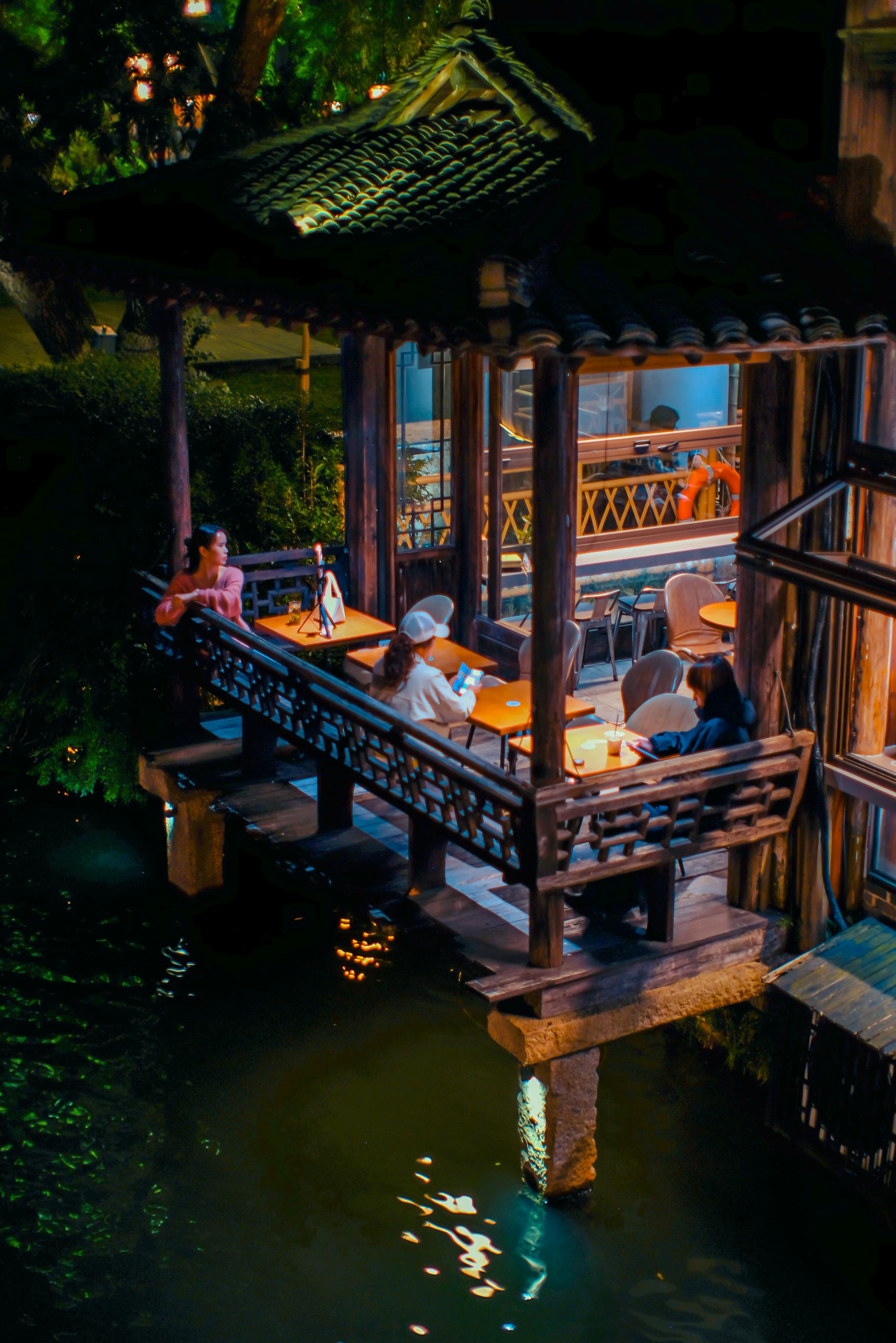 People enjoying relaxed life in Chengdu waterside pavilion at night