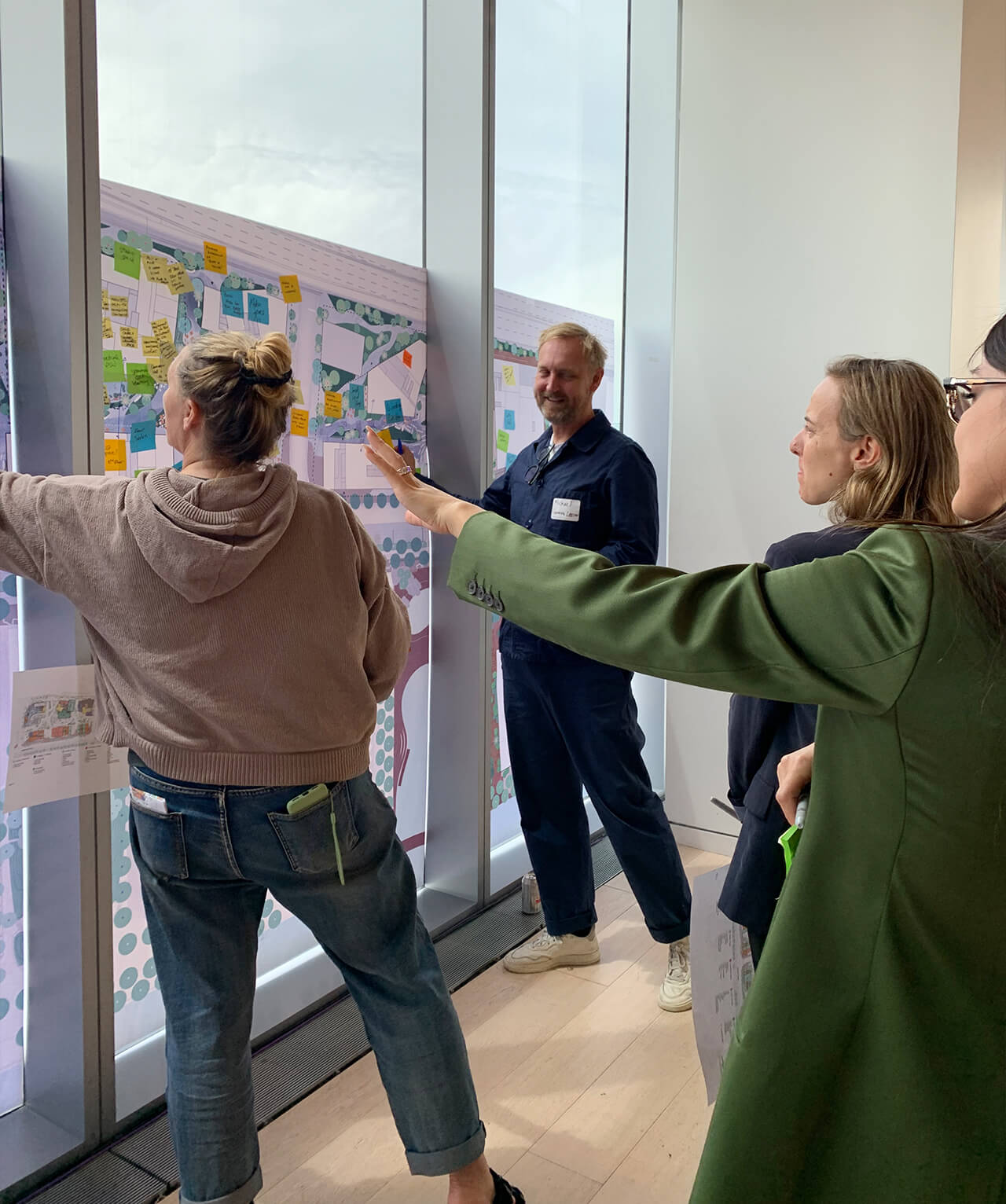 Workshop participants pointing towards a map of the site.