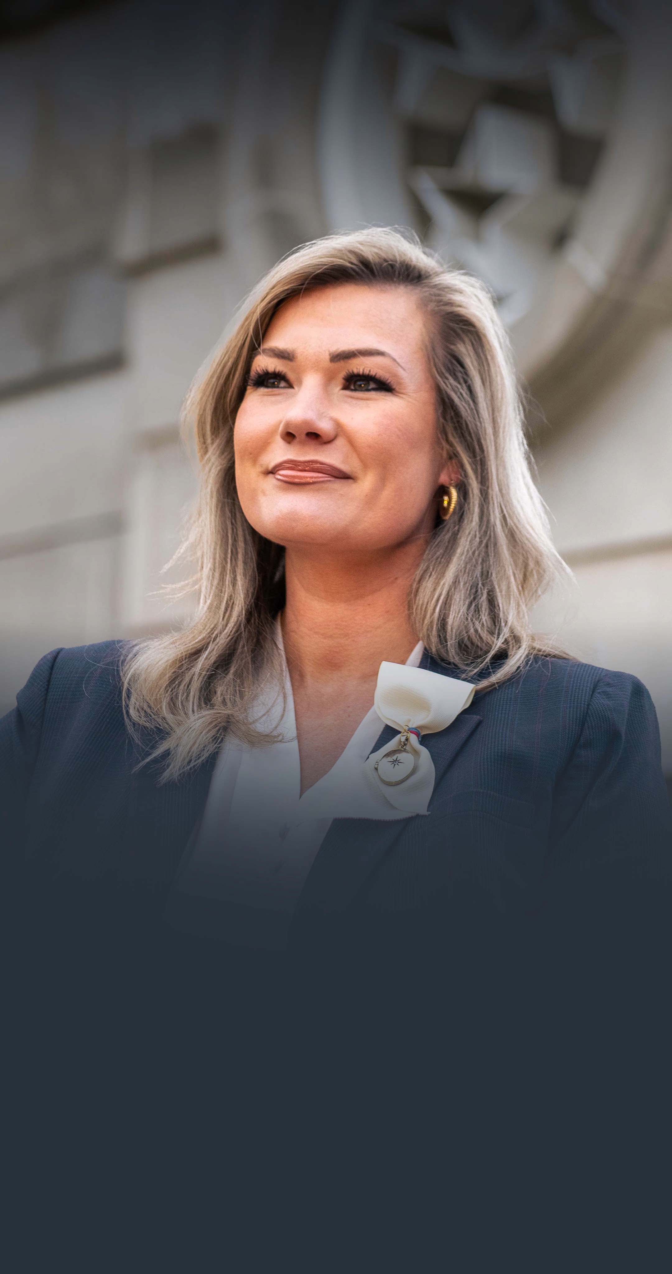 Lauren Pinkston, standing beside the TN state flag logo in Bicentennial Mall State Park, Nashville, TN