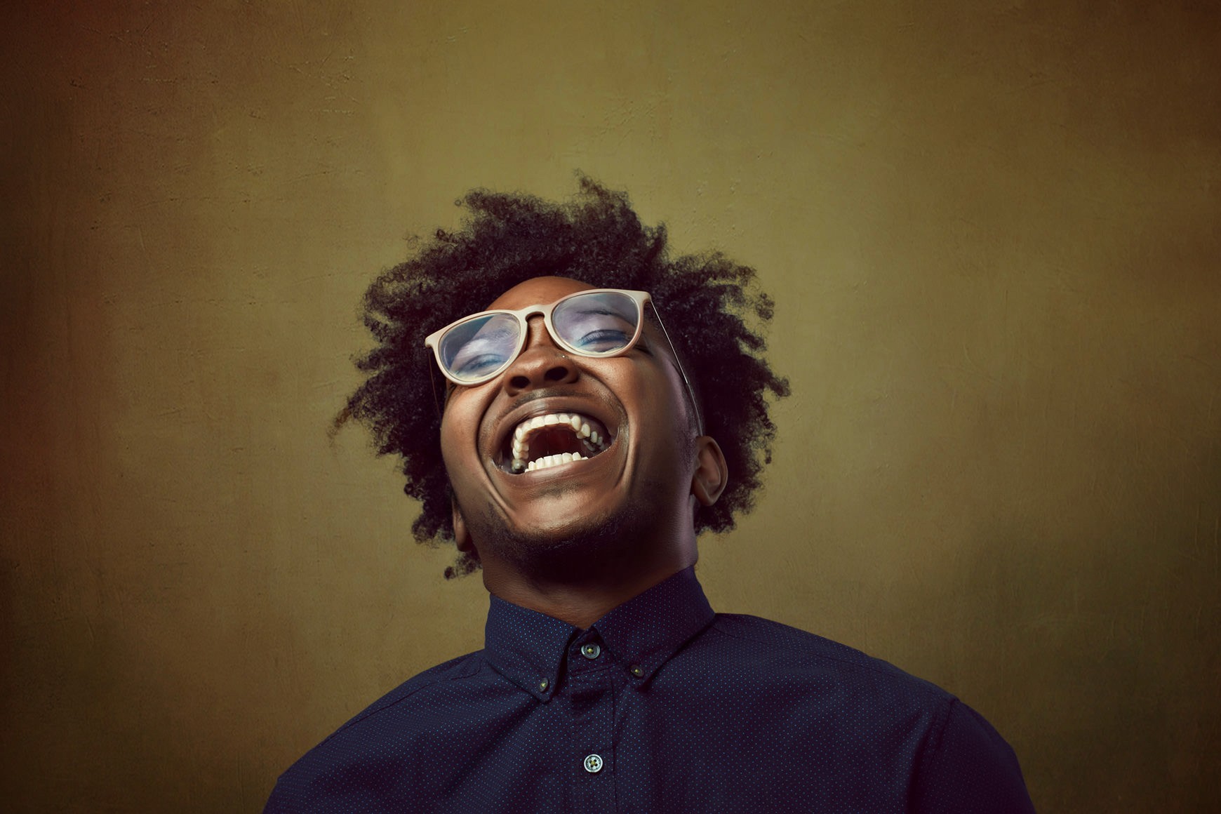 Editorial-style portrait of bald white man with beard in leather jacket