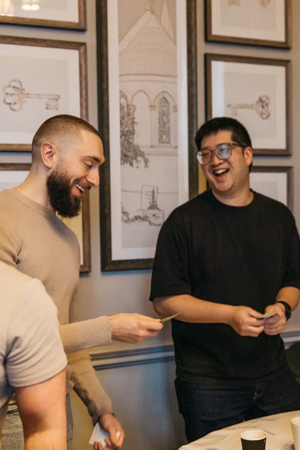 Two people smiling and sitting near a large framed photo.