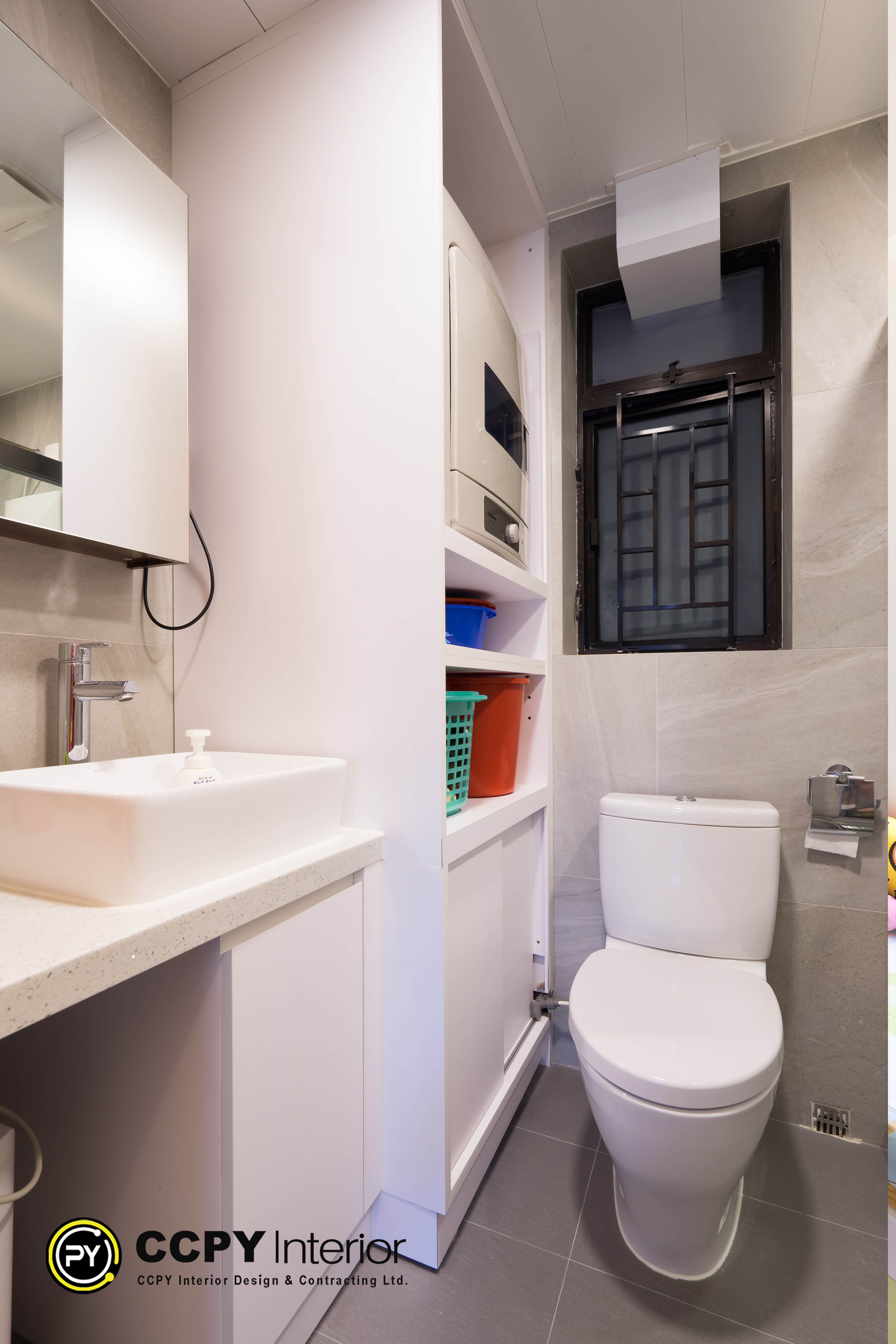 Optimized bathroom design for small bathroom layouts in Castello features white vertical storage alongside stone-effect tiling and a high-set window for ventilation.