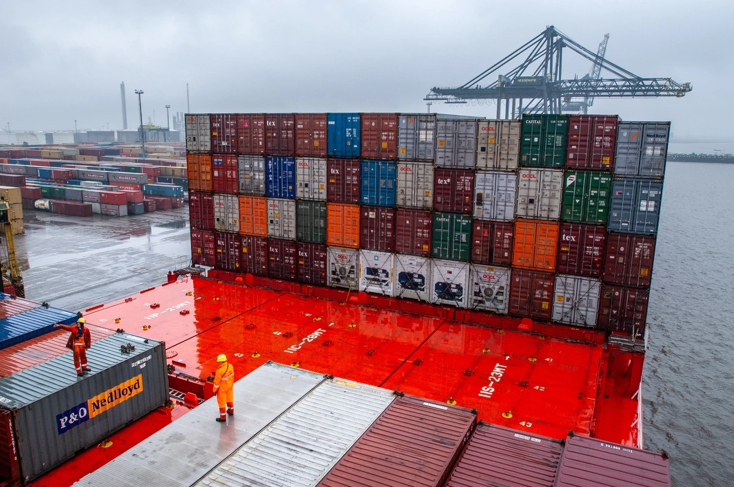 Containerumschlag im Hafen mit gestapelten Frachtcontainern vor der Überführung in das Zolllagerverfahren.