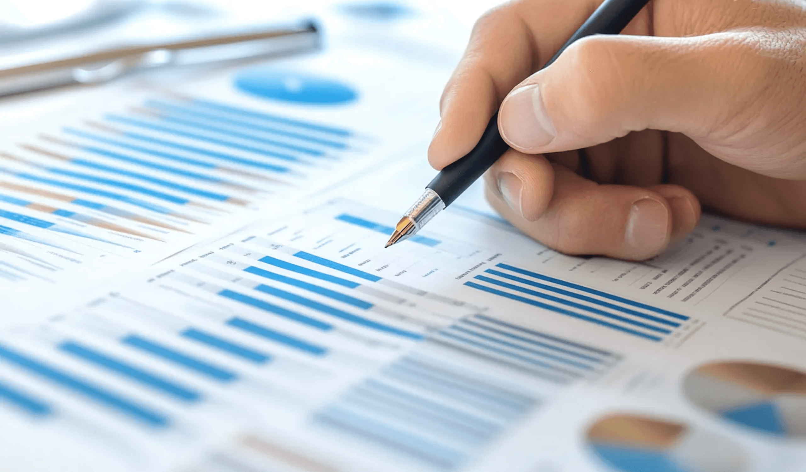 Hand pointing at financial charts.