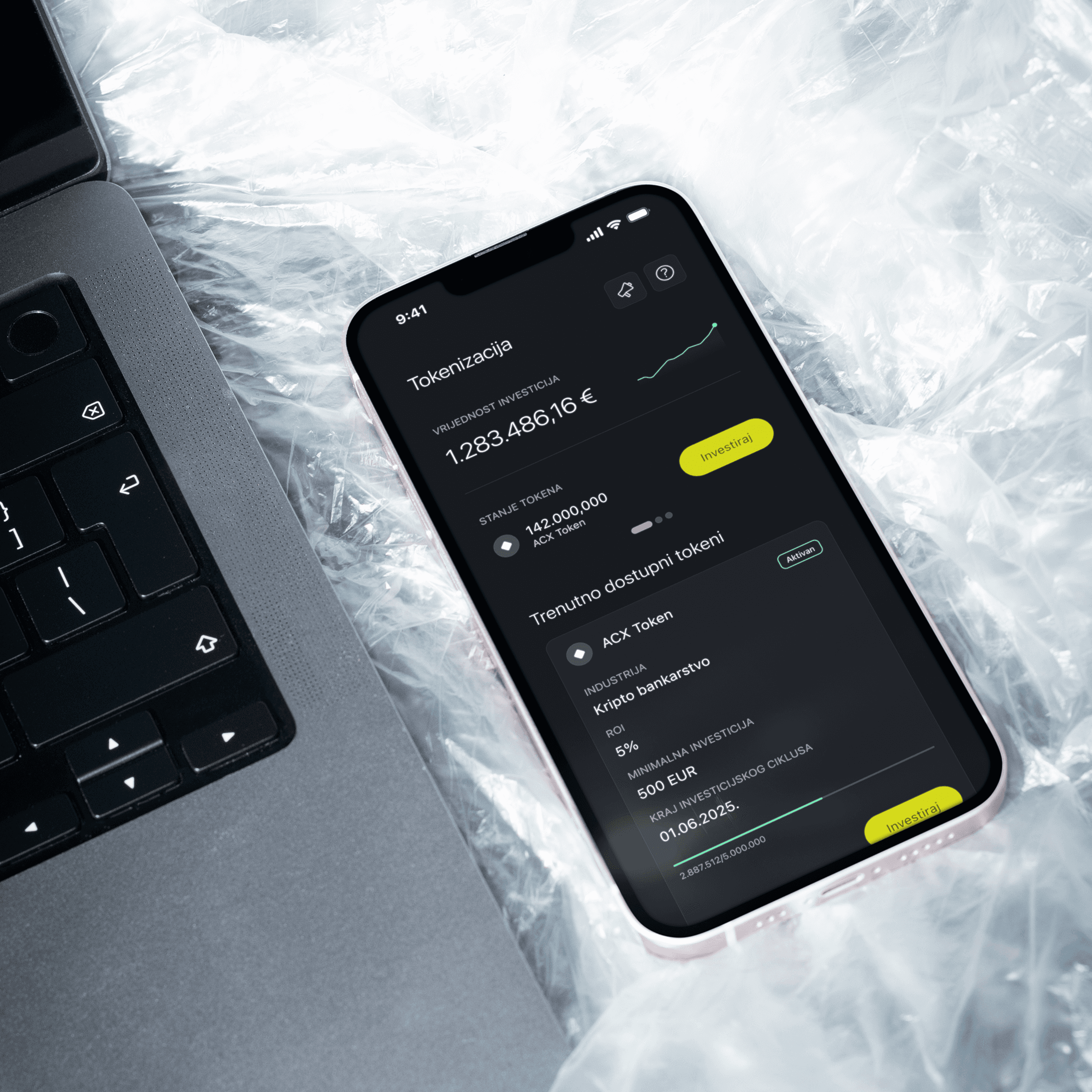 A phone placed on the crumpled nylon sheets, with its screen showcasing the tokenization feature of ACX's mobile app, designed by ofc. Studio.