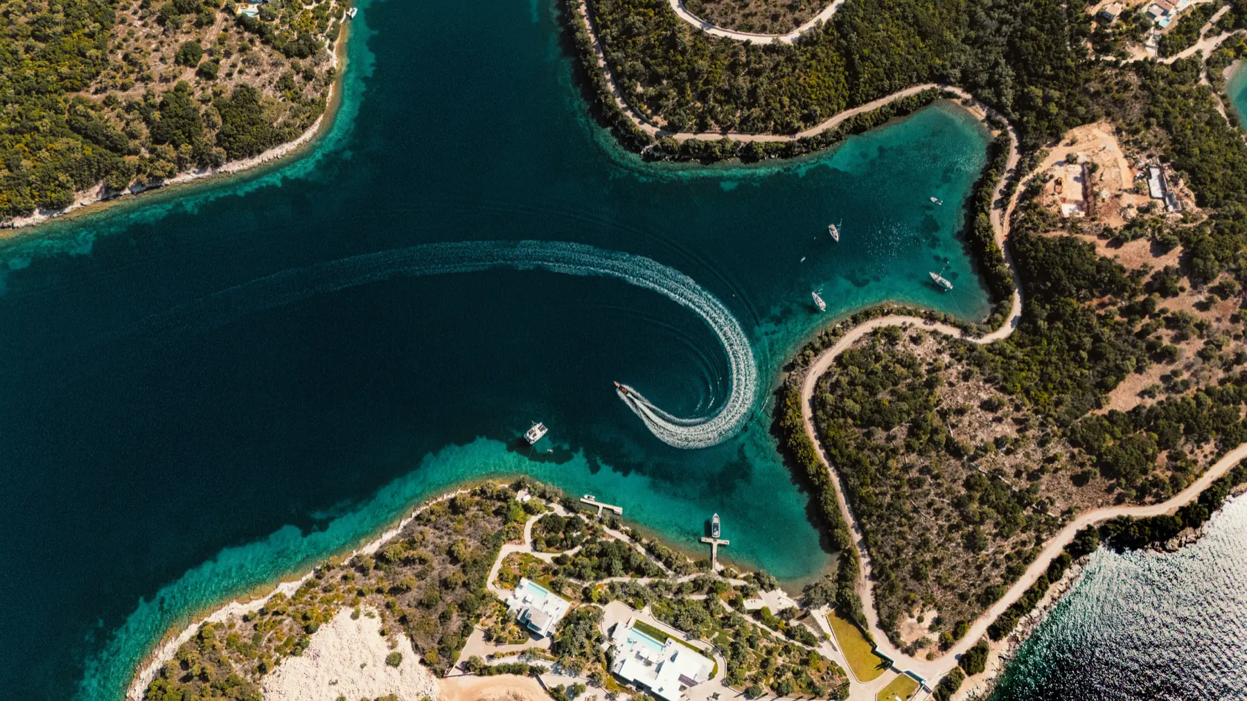 Vue aérienne de bateaux naviguant dans une baie insulaire aux eaux turquoise