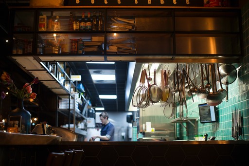 Foto de una cocina industrial de restaurante con utensilios de cocina colgando