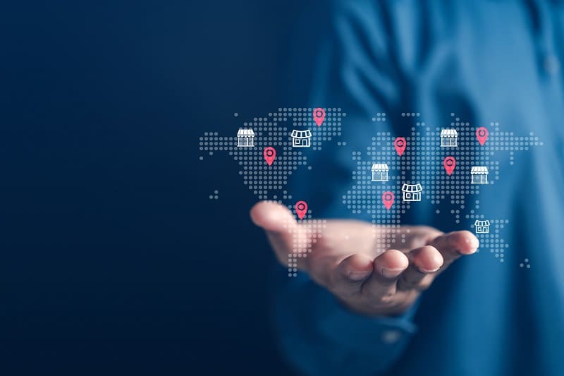 Person holding their hand out viewing all their business locations on a holographic map.