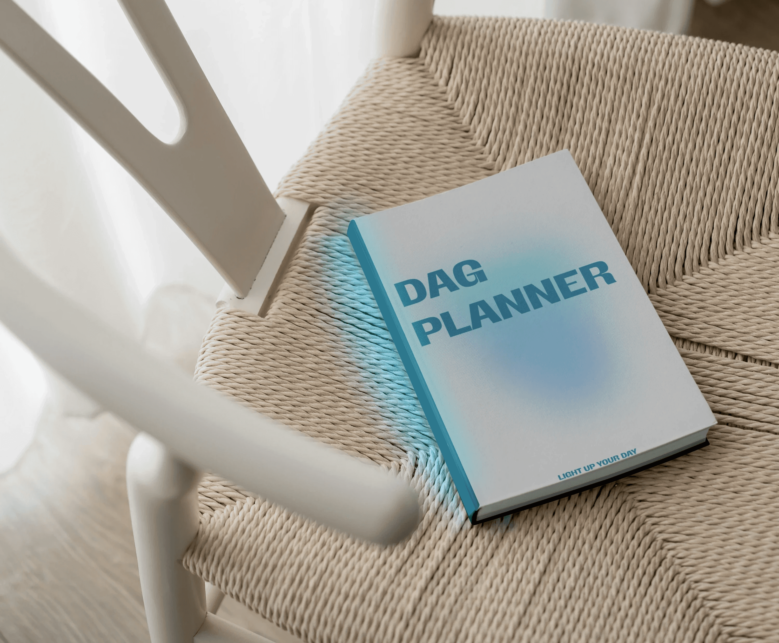 Person wearing black clothing carrying a black tote bag with a green globe-like geometric symbol, standing against a concrete wall in sunlight and shadow.