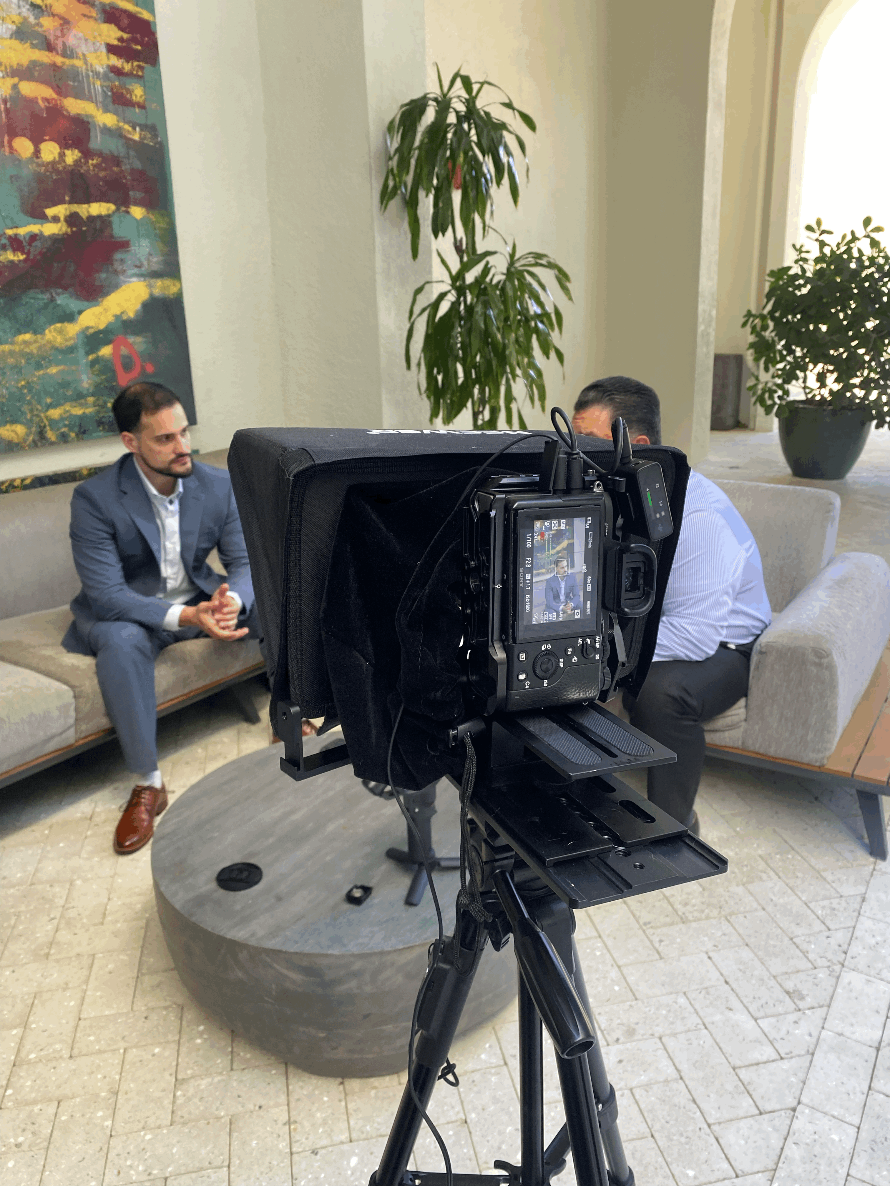 A woman stands in an office, with social media icons emerging from her laptop, symbolizing digital connectivity and engagement.