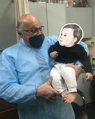 Dr. Ashraf Saddik sharing a gentle moment, looking at an infant patient at The Circumcision Doctor clinic in Melbourne.