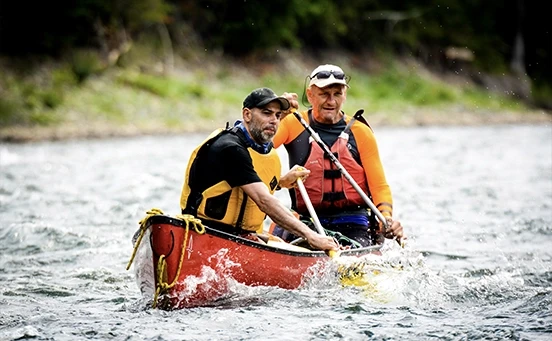 Hommes sur canoë avec gilets de sauvetage