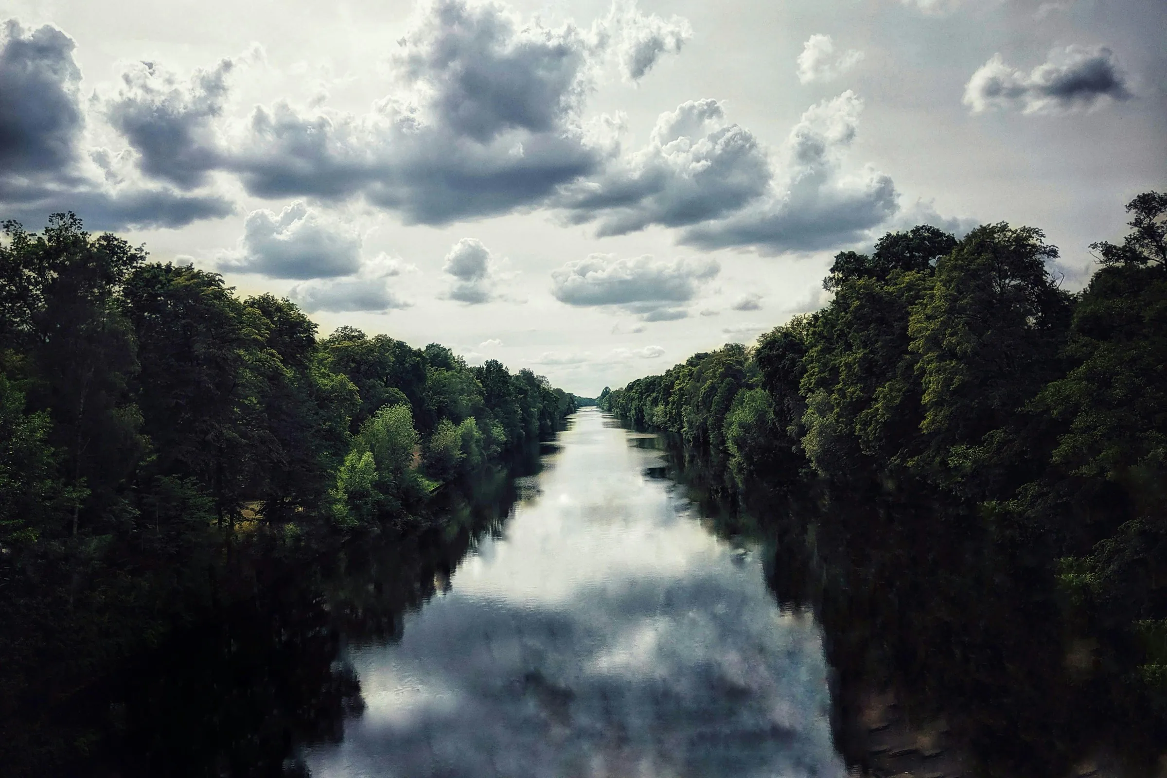 Berlin-Tegel, baumgesäumter Wasserlauf unter Wolkenhimmel