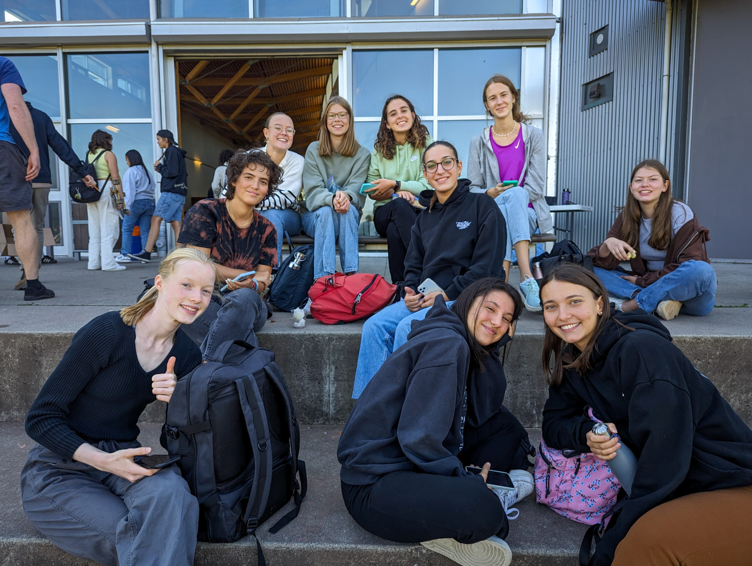 A multi-generational family poses for a group portrait outdoors.