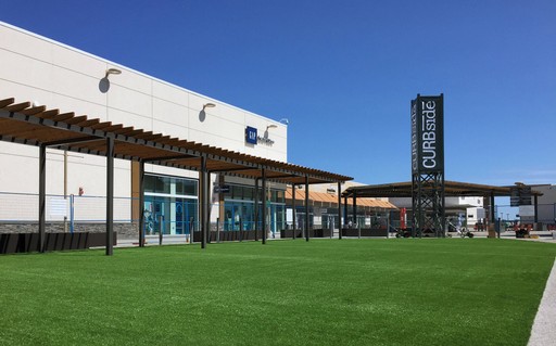 Outside, a mall showcases a large swath of AGL Grass and a lively shopping atmosphere.
