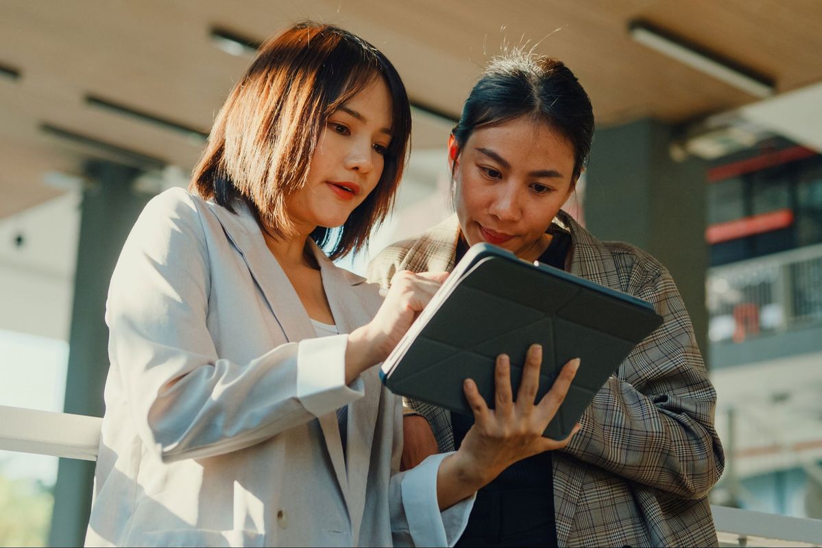 Smiling man and woman standing together in front of a framed abstract artwork.