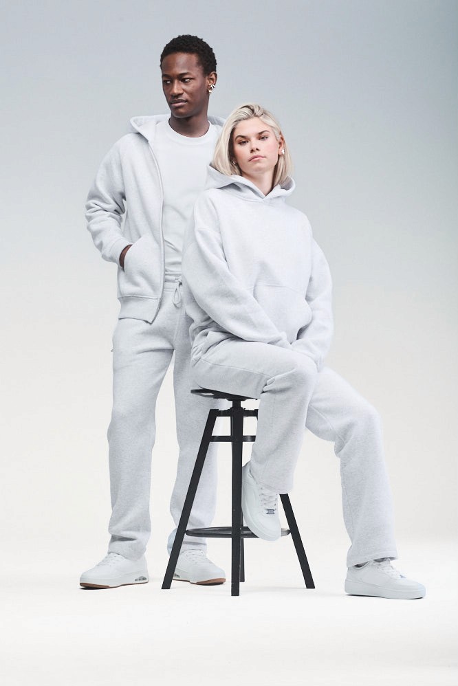 Two models wearing matching light grey Sunday Superior hoodie and sweatpants