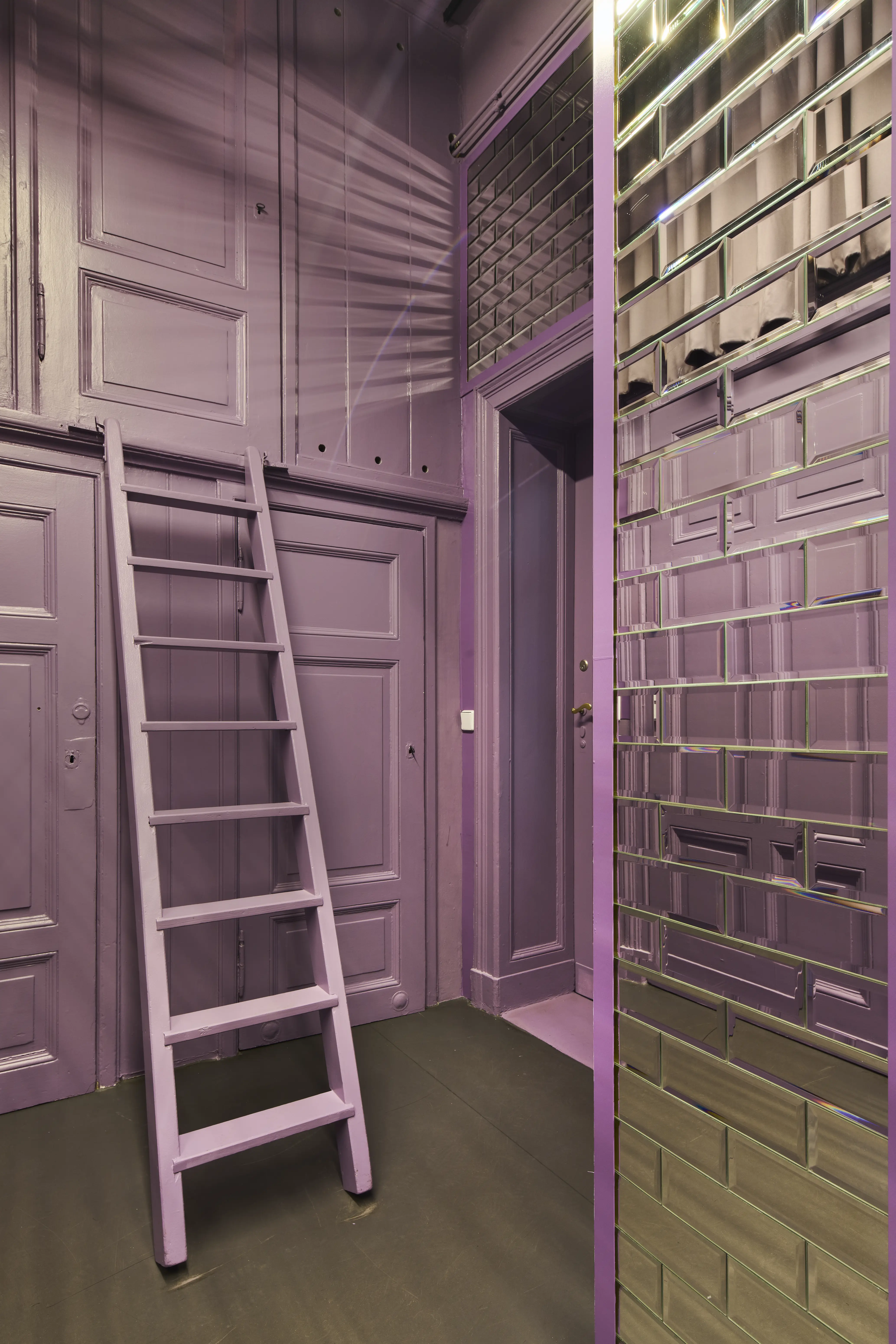 Lilac room with panelled doors, purple ladder and mirror tile wall in the Bold office.