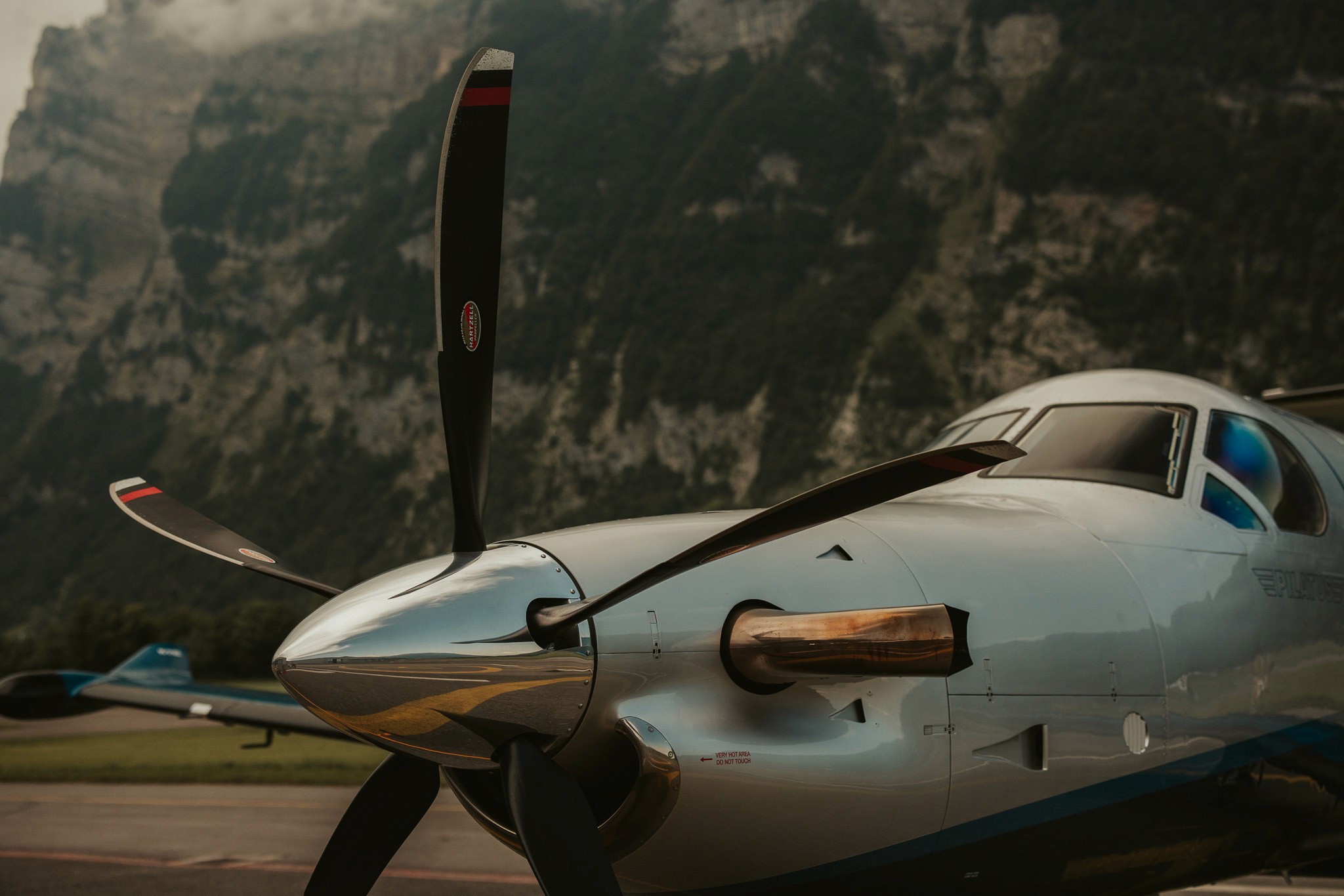 Close-up of the Pilatus PC‑12 NGX propeller and cockpit, reflecting the Swiss Alps in the background – showcasing Maremma’s high-performance fleet and alpine accessibility.