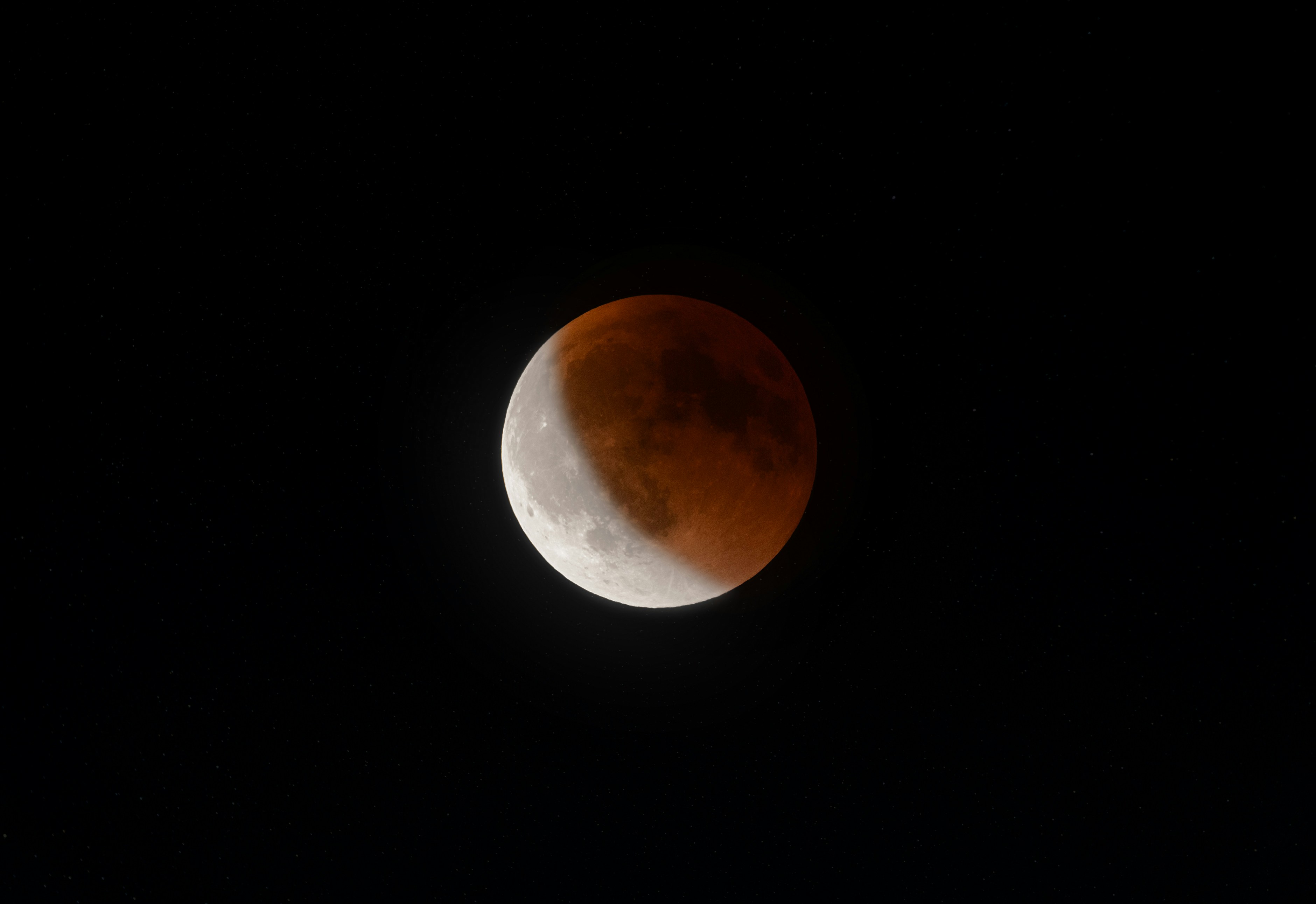 A blood moon lunar eclipse in the night sky.